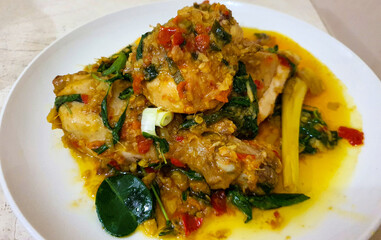 Ayam woku is a traditional dish from the Minahasa or Manado region of Indonesia, made of a chicken cooked mix of herbs and spices, ingredients are lemongrass, turmeric, kaffir lime leaves,