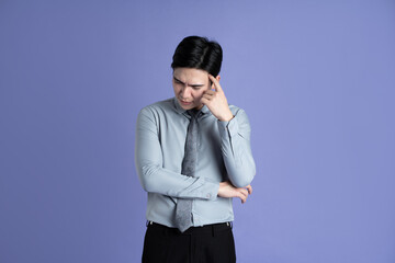 Portrait of Asian male businessman posing on purple background