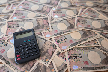 大量の一万円札と電卓　10,000 yen bills and calculator - obrazy, fototapety, plakaty