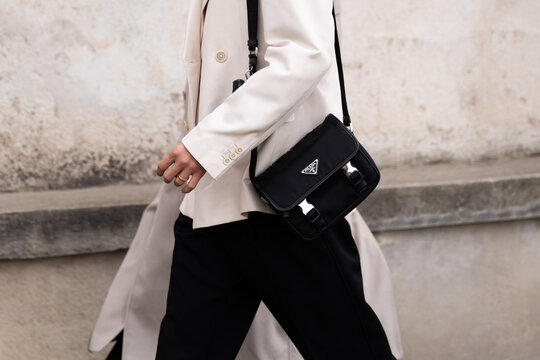 Milan, Italy - January, 14, 2024: man wears leather bag from Prada Re-Nylon and Saffiano, street style handbag details, fashion outfit detail