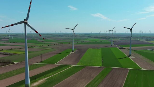 Aerial view of wind turbines and agriculture fields. Windmills turbines generating electricity, green energy, panorama 4k