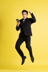 Fototapeta na wymiar Portrait of Asian male businessman. wearing a suit and posing on a yellow background
