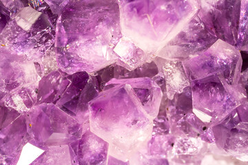 Fototapeta premium Amethyst purple crystals. Gems. Mineral crystals in the natural environment. Texture of precious and semiprecious stones. Seamless background with copy space colored shiny surface of precious stones.