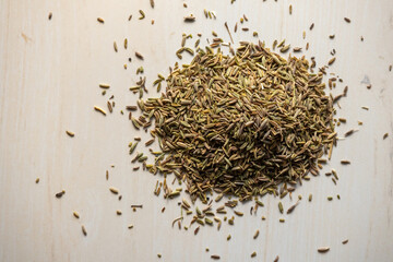 Cumin seeds pile on wooden background. Locally in Bangladesh, it is called Jeera. Cumin seeds are...