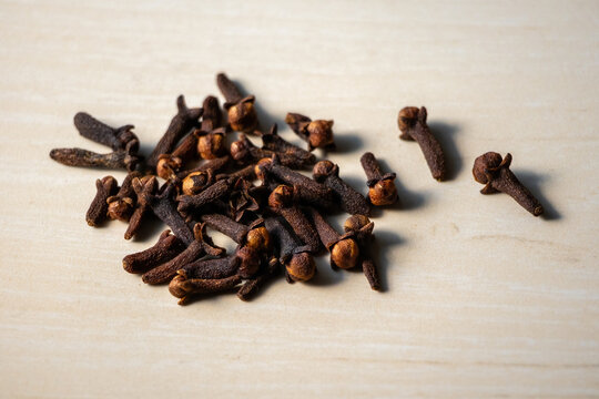 A pile of aromatic dry cloves on a wooden background. Locally in Bangladesh, it is called Lobongo.