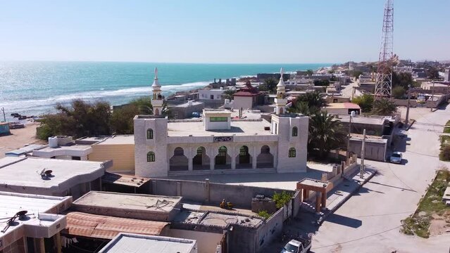 White mosque in the beach sea side religious place of worship in coastal city rural village in countryside seaside town local people life sailor fishermen work on old wooden boat in Iran Qatar border