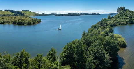 Fototapeta na wymiar Sailboat and forest in the calm Lake Rotoiti, Rotorua, Bay of Plenty, New Zealand.