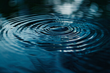 Zoom in on a water drop making tiny waves in a circle.