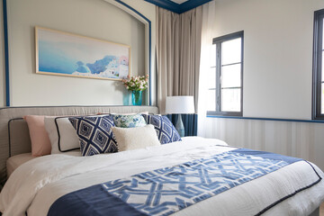 White and blue coastal style bedroom with sided table lamp.
