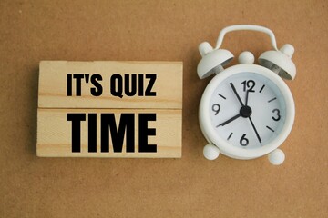 bell and clock stick with the words Its Quiz Time. the concept of answering quizzes or quiz games