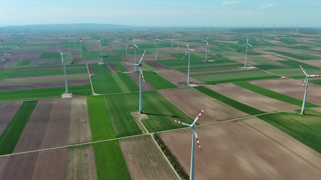 Aerial view of wind turbines and agriculture fields. Windmills turbines generating electricity, green energy, 4k