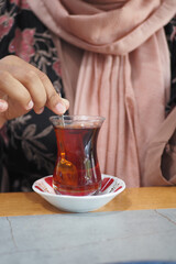 woman drinking Traditional turkish tea on white table .
