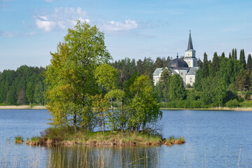 Fototapeta na wymiar Warm summer landscape with an old Lutheran church. Ruokolahti, Finland