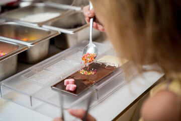 Baby girl in the workshop during a lesson on making handmade chocolates and sweets