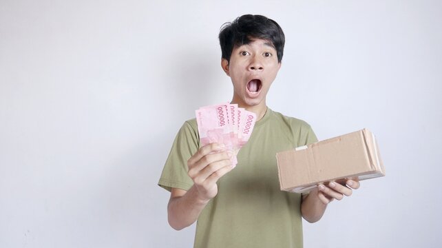 shocked asian man holding package and money
