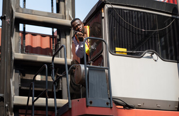 African logistic engineer man worker or foreman working and driving forklift container at container site