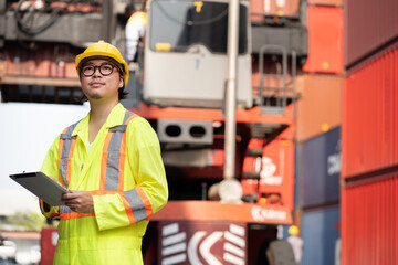 Asia logistic engineer man worker or foreman working with tablet computer and forklift container background at container site	 - 766118270