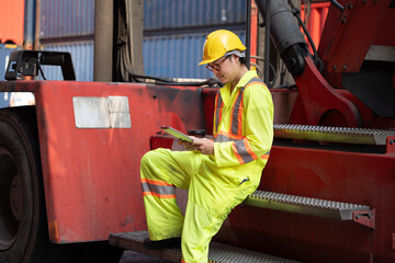 Asia logistic engineer man worker or foreman working with tablet computer and forklift container at container site	 - 766118273
