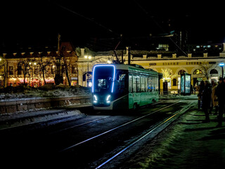 modern tram on the night winter street of the city