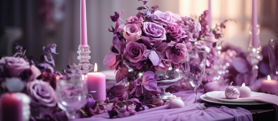 The table at the event is adorned with vibrant purple flowers and flickering candles, creating a...