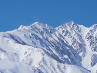 Fototapeta na wymiar 冬の白馬村から見る冠雪した北アルプス　遠景