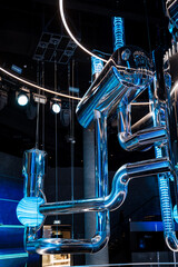Electric blue pipes hang from ceiling, resembling art installation