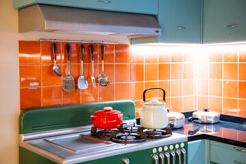 Kitchen with green gas stove and orange tile countertop