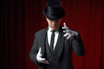 Waist-up portrait of handsome man magician showing mysterious trick on stage