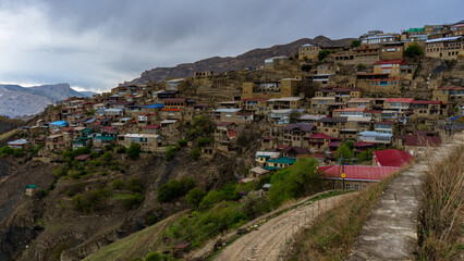View of mountain village against beautiful spring landscape on evening. Houses on the mountainside, old aul Chokh in Dagestan republic, Russia. Caucasian ancient settlement, Caucasus
