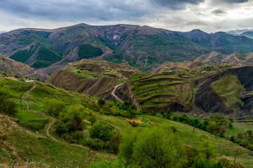 Fototapeta na wymiar Beautiful spring landscape with mountain valley and hills in mountainous area. Green mountainsides on evening. Chokh terraces, urban and natural landmark of Dagestan republic, Russia. Amazing nature