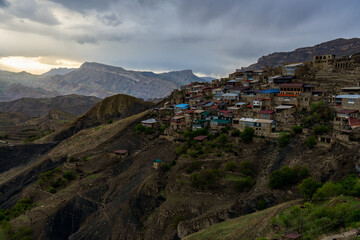 View of mountain village against beautiful spring landscape on evening. Houses on the mountainside, old aul Chokh in Dagestan republic, Russia. Caucasian ancient settlement, Caucasus