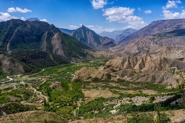 Fototapeta na wymiar Amazing spring panoramic landscape in mountainous area. Mountains, valley and road from Gunib to Karadakh in Dagestan, Russia. Wonderful nature, beautiful natural background. Picturesque scenery