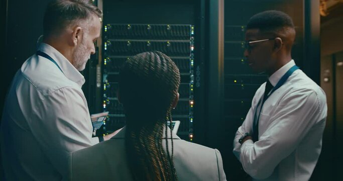 Team, tablet coding and server room for planning, digital screen programming or cloud computing solution. Manager, technician or group of people in data center for system or hardware problem solving
