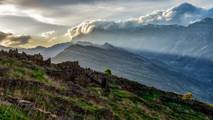 Picturesque mountain spring landscape at sunset. Old ruined aul against amazing scenery with...
