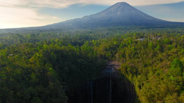 beautiful jungle waterfall in East Jawa, Tumpak Sewu waterfall aerial view at sunrise, drone shot of an Indonesian jungle waterfall, famous tourist destination in Java, Indonesia