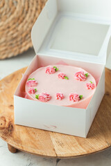 Cute little pink bento cake in the white gift box decorated with cream flowers roses. Trendy Korean...