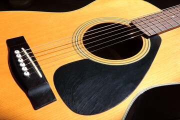 弦の一部が光を反射するアコースティックギター © Kogure