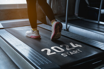 Happy new year 2024,2024 symbolizes the start of the new year. Close up of feet, sportswoman runner running on treadmill in fitness club. Cardio workout. Healthy lifestyle, guy training in gym. - obrazy, fototapety, plakaty