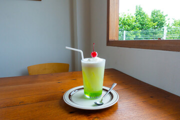 Melon soda float with vanilla ice cream and cherry on top in summer time,Melon soda is one of the...