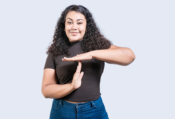 Smiling woman showing time out gesture isolated. Young woman making time out gesture with palms...