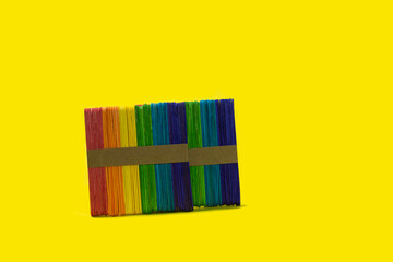 colorful popsicle sticks on a bright yellow background Ready to work on ideas