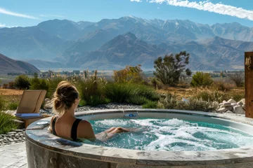 Fotobehang Woman relaxing in hot tub surrounded by scenic mountains. Generative AI © Eugen