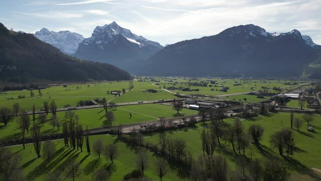 A captivating aerial view captures Weesen, a charming village nestled in See-Gaster, Canton of St. Gallen, Switzerland. Traffic flows along the highway, weaving through the valley amidst houses.
