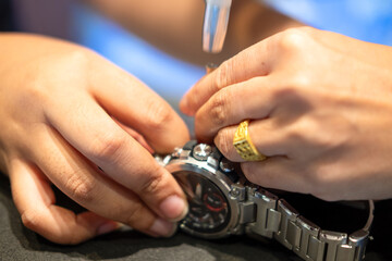 Obraz premium Watchmaker using spring bar tool. Spring bar tool used to remove spring bars to change watch strap.