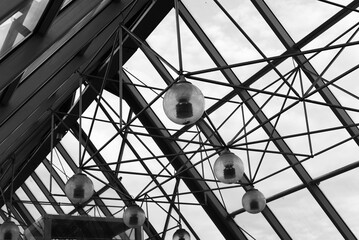 Beautiful ceiling structure made of steel and glass with a view of the sky in black and white.
