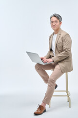 A middle-aged male teacher in a suit and glasses is sitting in a chair, holding a laptop, working with various expressions and poses.
