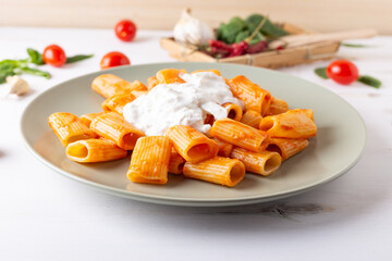Macaroni with tomato sauce and stracciatella. Good and balanced Italian cuisine dish