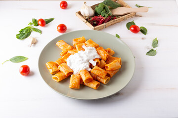 Macaroni with tomato sauce and stracciatella. Good and balanced Italian cuisine dish