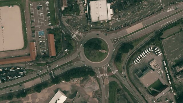 Aerial top down shot of roundabout traffic and car parking lots in an industrial area of Nice, France