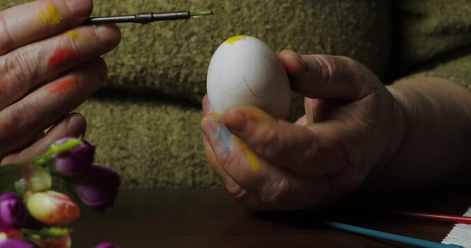 woman delicately paints vibrant designs on Easter eggs, eagerly preparing for the upcoming holiday festivities.